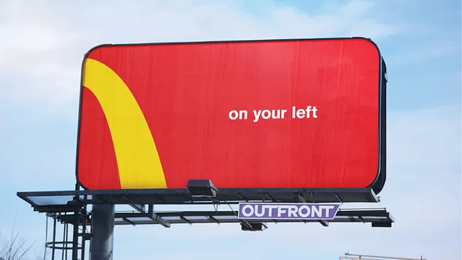 A red and yellow McDonald's billboard ad showing the simple text "on your left".